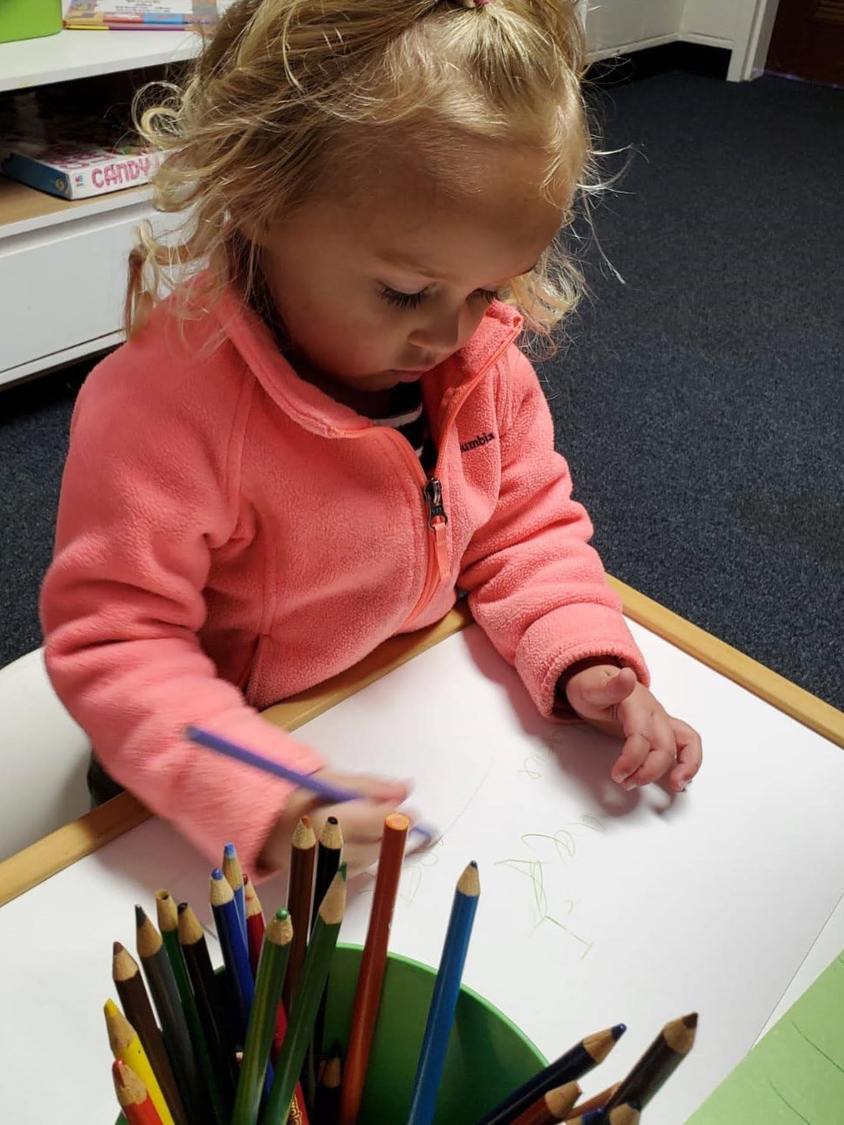 A little boy draws while learns Spanish at MIA Learning Center